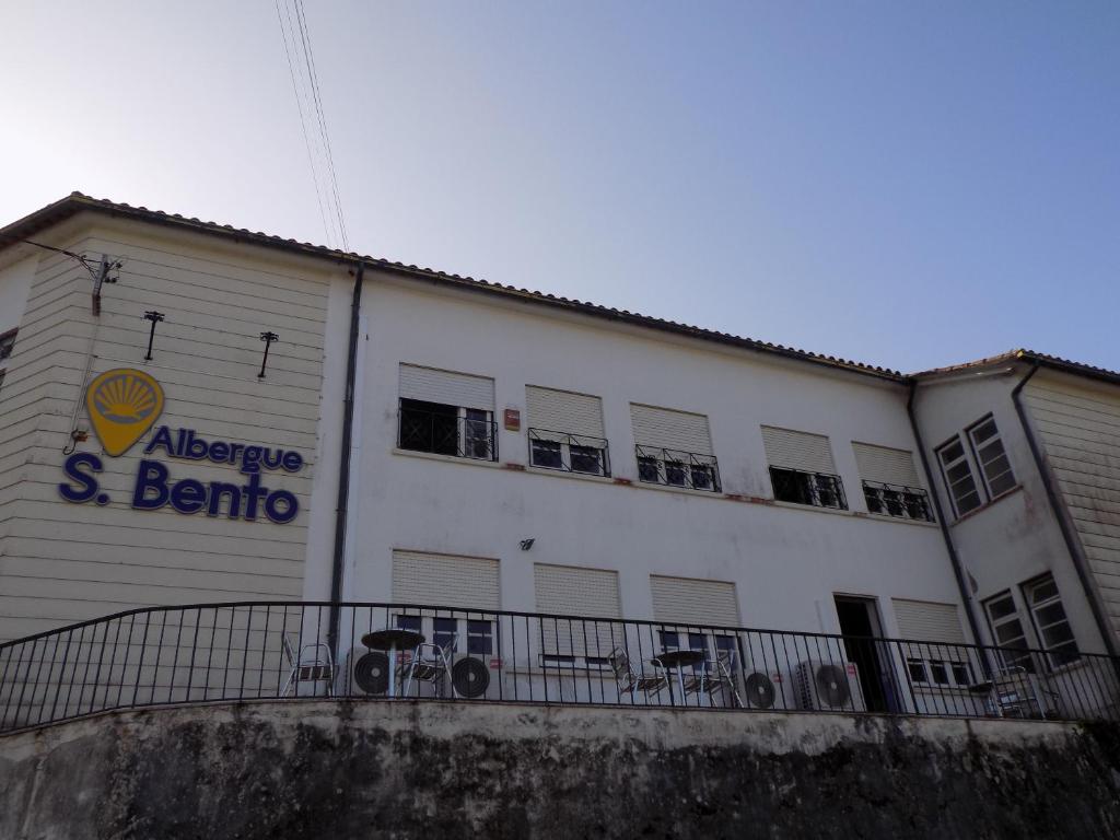 卡米尼亚Albergue de São Bento的白色的建筑,旁边标有标志