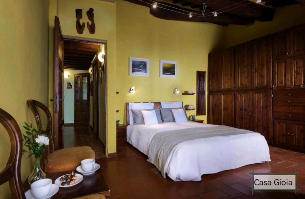 皮恩扎PienzaLettings "Casa Gioia"的卧室设有一张白色大床和黄色墙壁