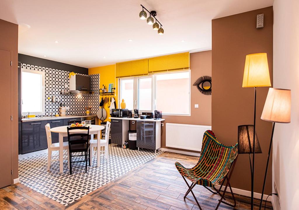 拉卡诺La COLOC的厨房设有黄色的墙壁和桌椅