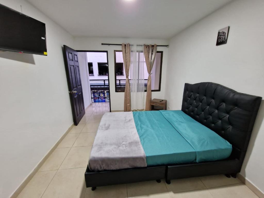 佩雷拉Las Margaritas apartments, Pereira City Centre的一间卧室配有一张床和一台平面电视