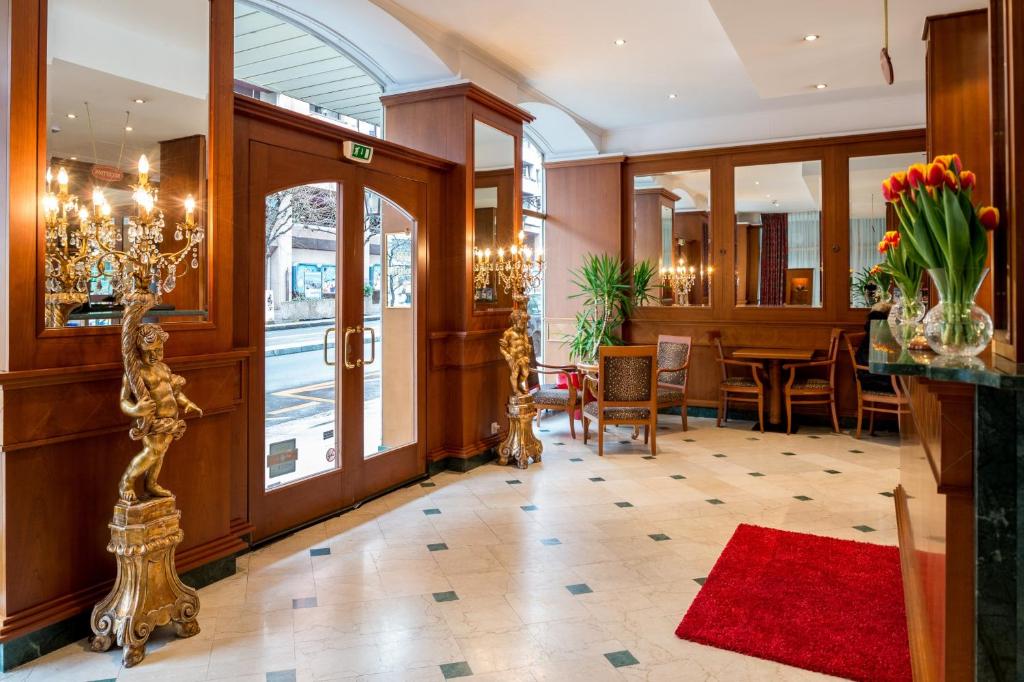 日内瓦迪普乐玛特酒店的酒店大堂设有桌椅