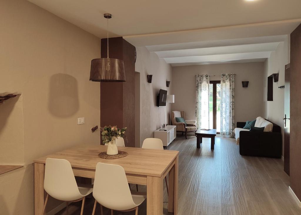 帕尔斯Can Costals Naturaleza的厨房以及带木桌和椅子的客厅。