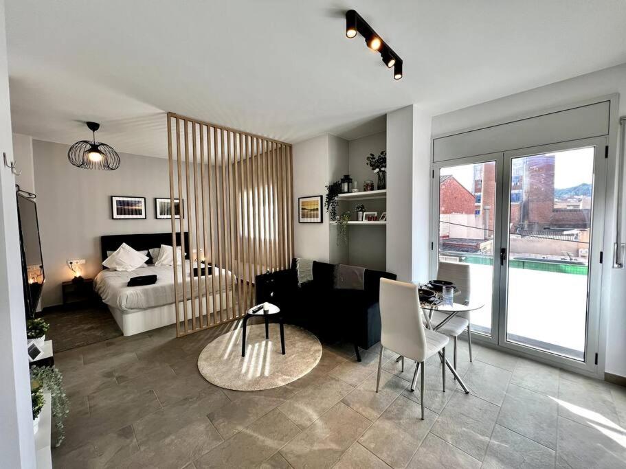 特拉萨Loft moderno en buena ubicación的一间带一张床的客厅和一间带桌子的房间