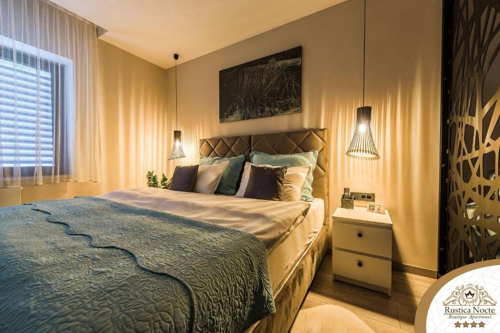 波热加Rustica Nocte Boutique Apartments的一间卧室配有一张带蓝色毯子的大床