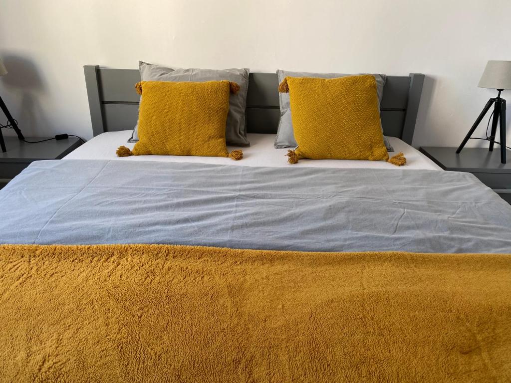 卡托维兹Słoneczny apartament的一张大床,上面有两个黄色枕头