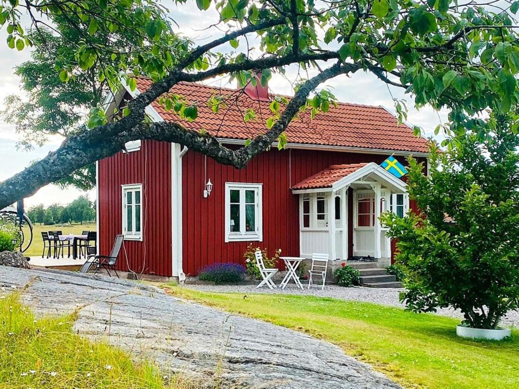 TallbackenHoliday home LIDKÖPING VIII的前面有一张桌子和椅子的红色房子