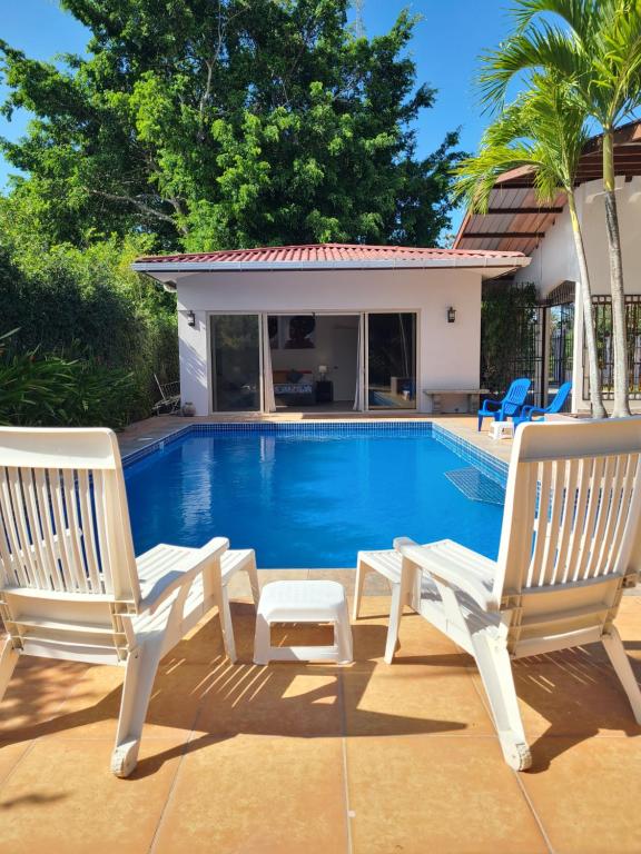 戴维Pool House with Shared Pool Access的两把白色椅子坐在游泳池旁