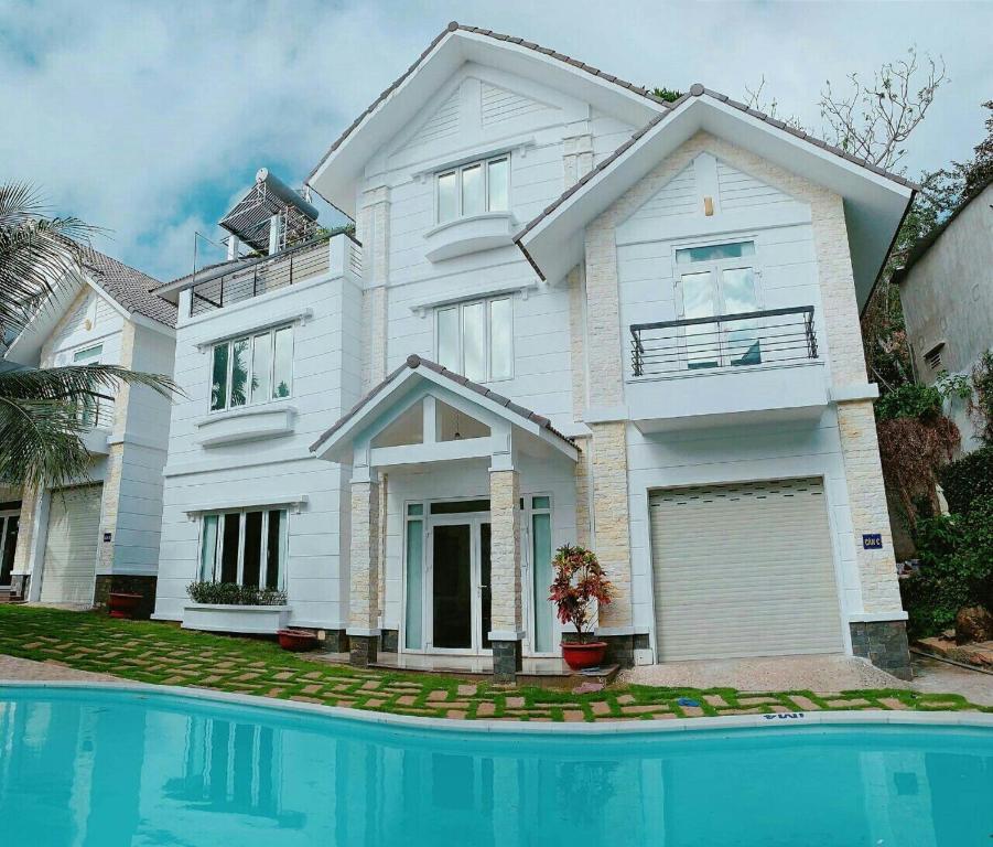 头顿Rio 009 homestay的一座白色的房子,前面设有一个游泳池