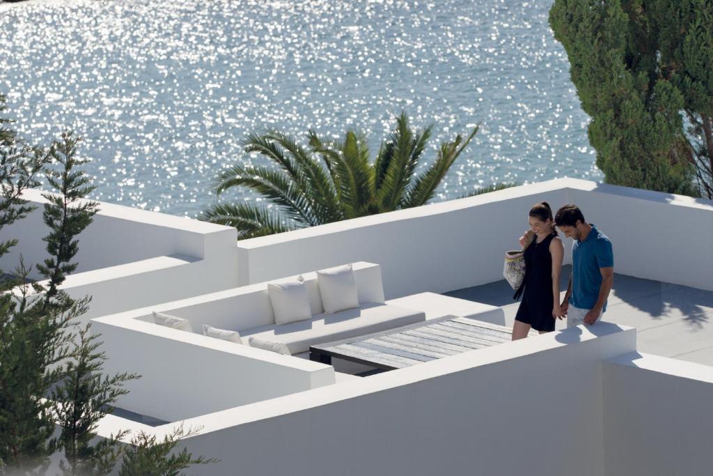 帕福斯奥尔迈拉酒店的两个人站在一个水景阳台上