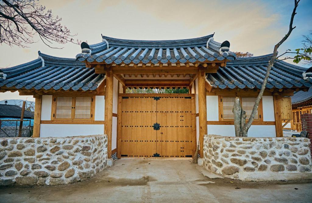 求礼郡Hanok Stay - JukRokJungSa的通往有屋顶的建筑物的大门