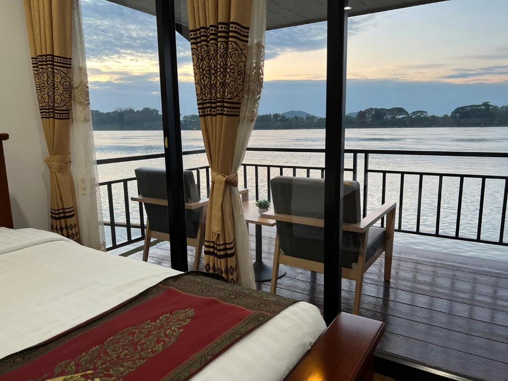 Ban Mai Ta SaengRiverside Chiangkhan的一间卧室设有享有水景的阳台