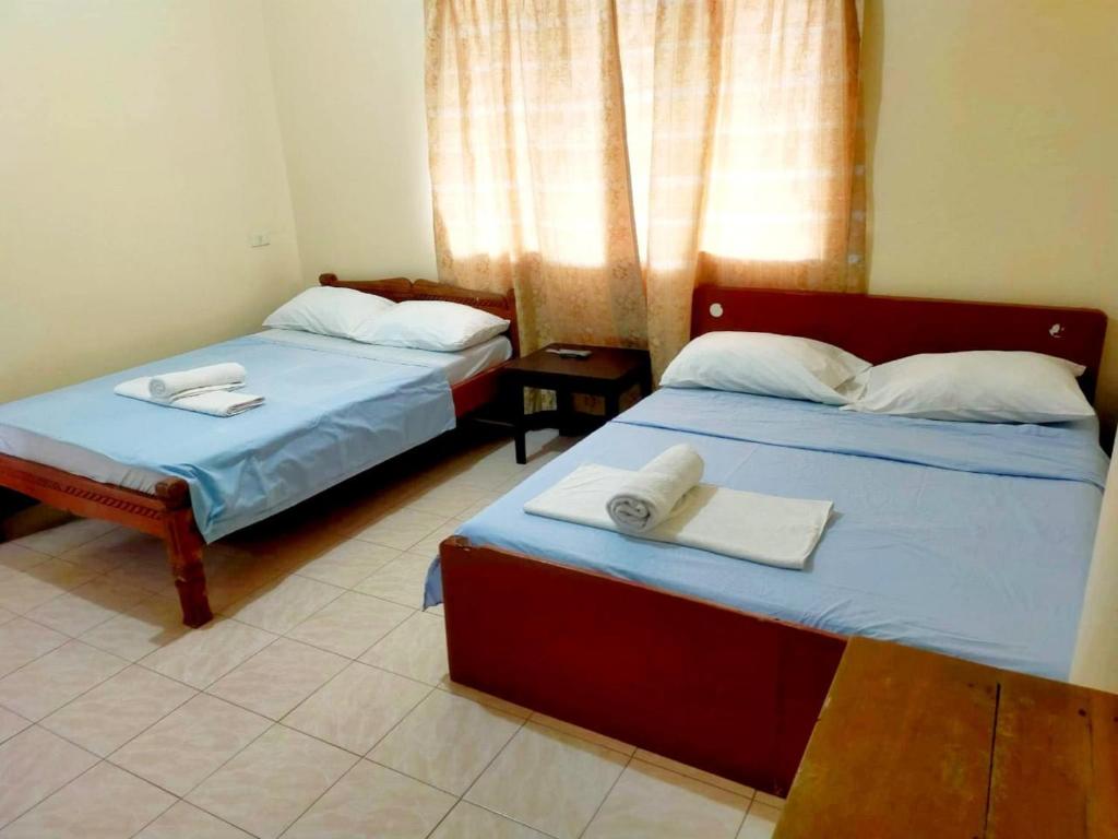 长滩岛OYO 931 Moreno's Place的客房内的两张床和毛巾