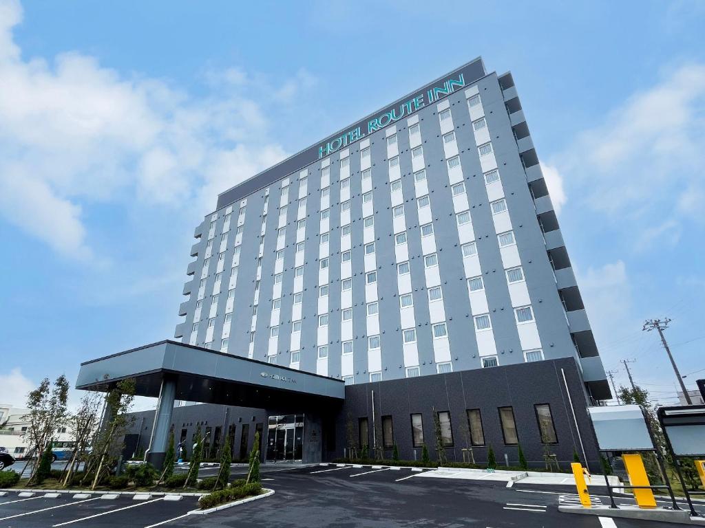 铫子市Hotel Route Inn Choshi Eki Nishi的酒店大楼前面设有停车场