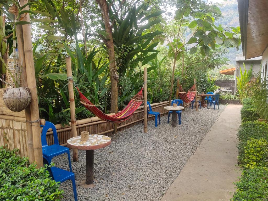 NongkhiawMeexok guesthouse的花园里的一组椅子和吊床