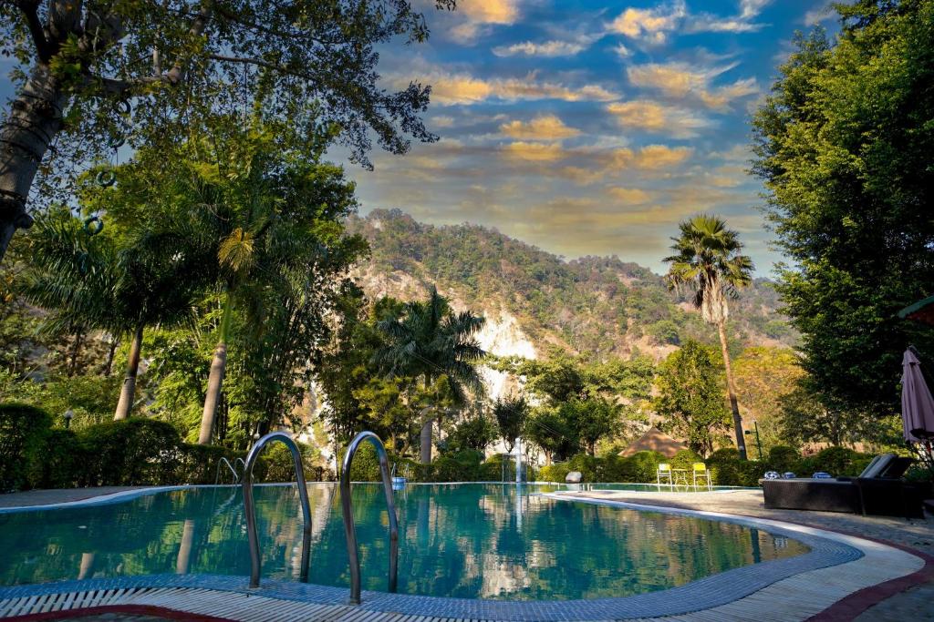 加尔加索尔鲁纳度假酒店的一座树木繁茂的游泳池,一座山底