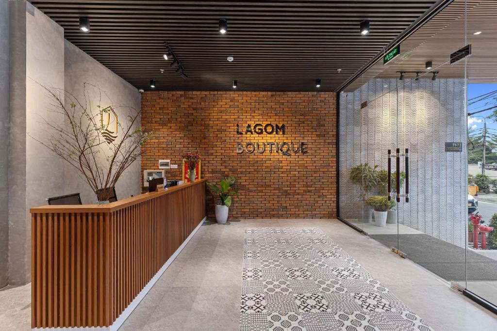 岘港Lagom Boutique Hotel Da Nang的大堂设有前台和砖墙