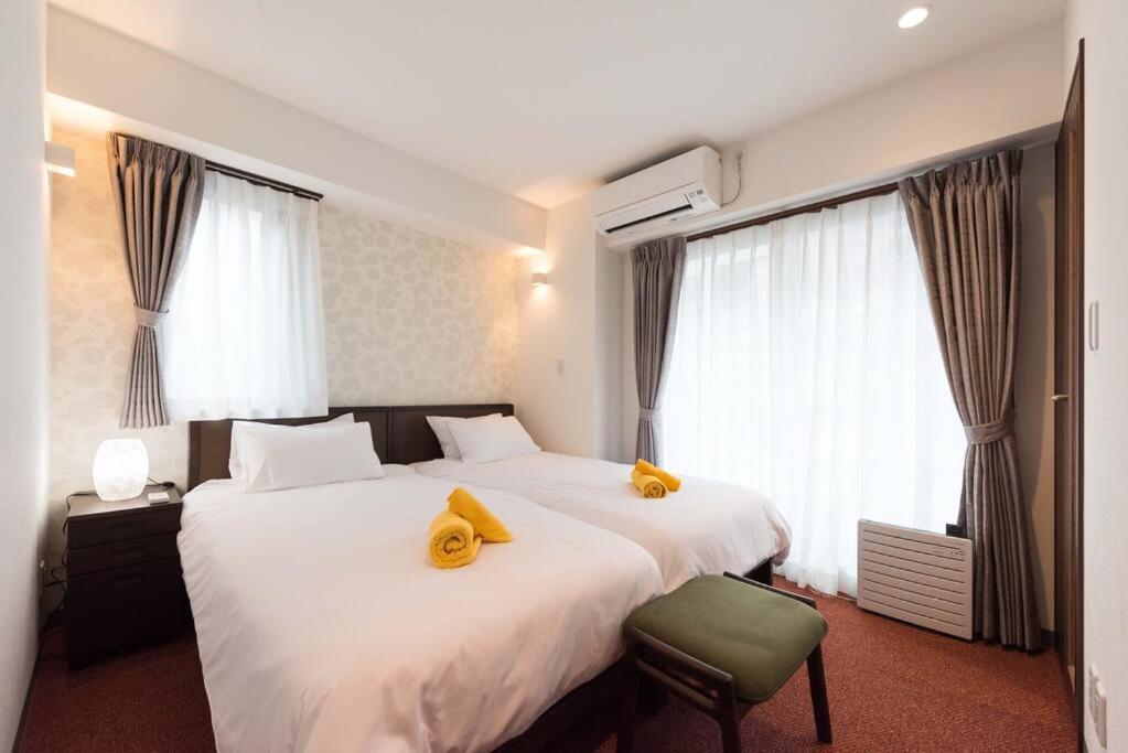 东京Serorin Light Hotel Tokyo的酒店客房带两张带黄毛巾的床。