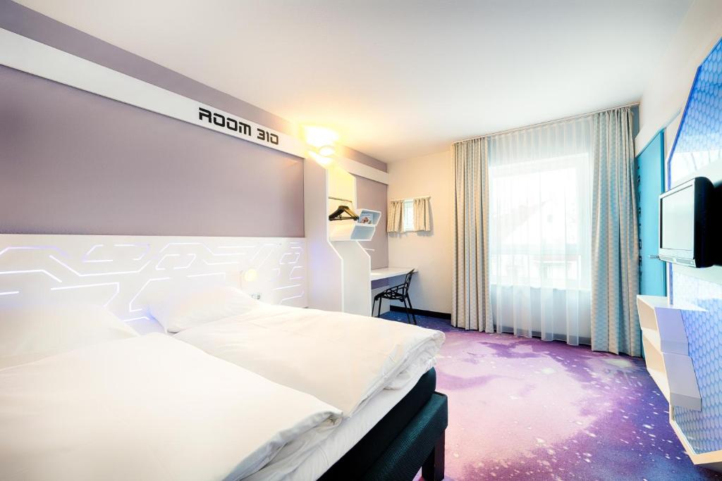 不莱梅B&B Hotel Bremen-Altstadt的一间酒店客房,配有一张床和一台电视