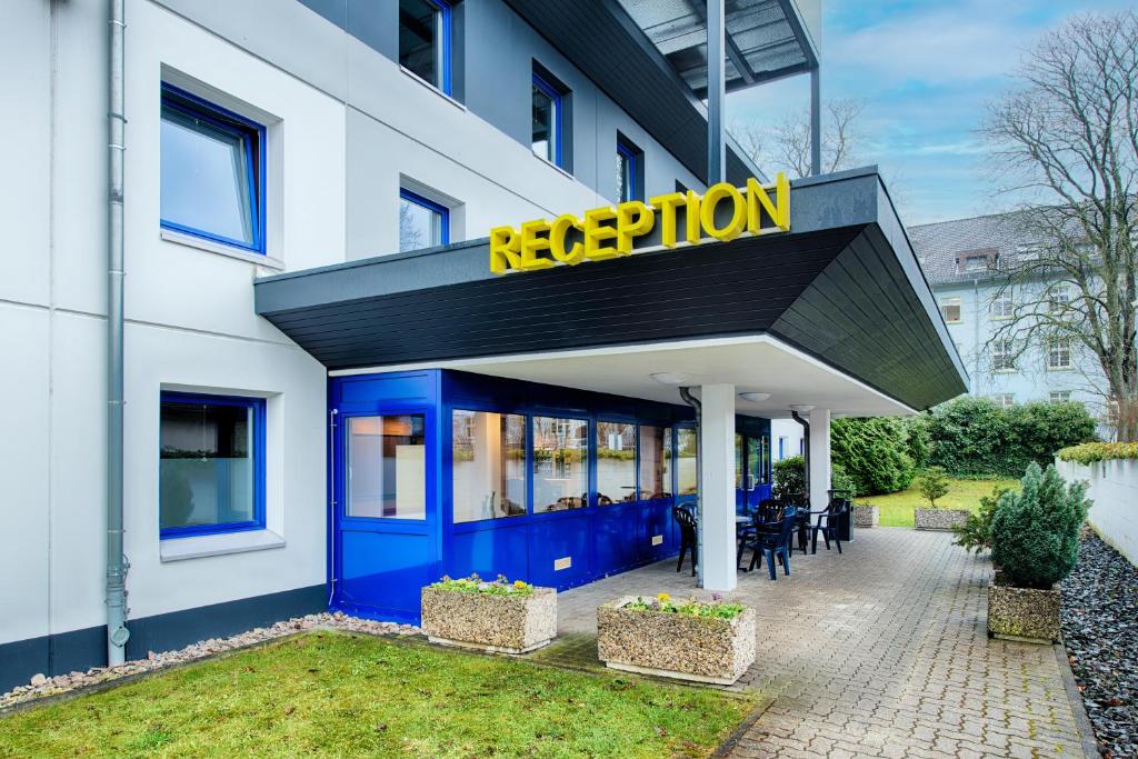 比勒费尔德B&B Hotel Bielefeld-Ost的大楼内一间有蓝色和黄色标志的餐厅