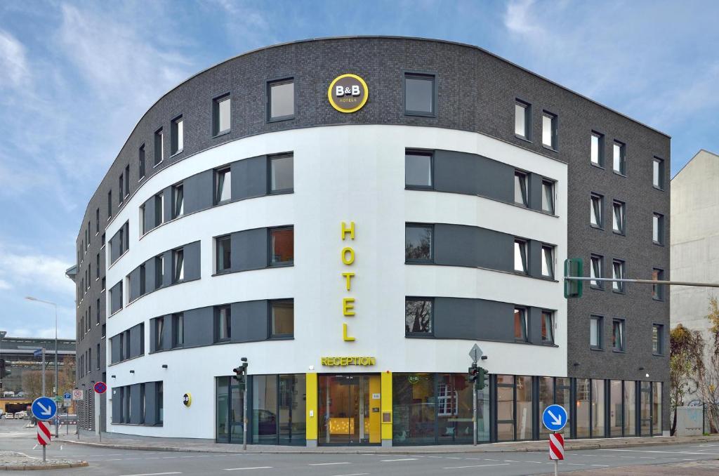 爱尔福特B&B HOTEL Erfurt-Hbf的一座白色的大建筑,上面有黄色的标志