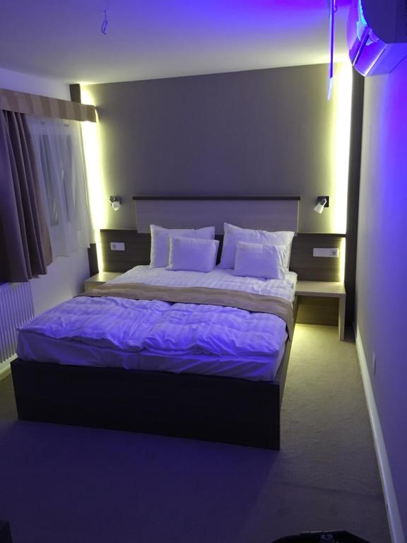 奥巴曹洛克Tündérfátyol的一间卧室配有一张带紫色床单和枕头的床。