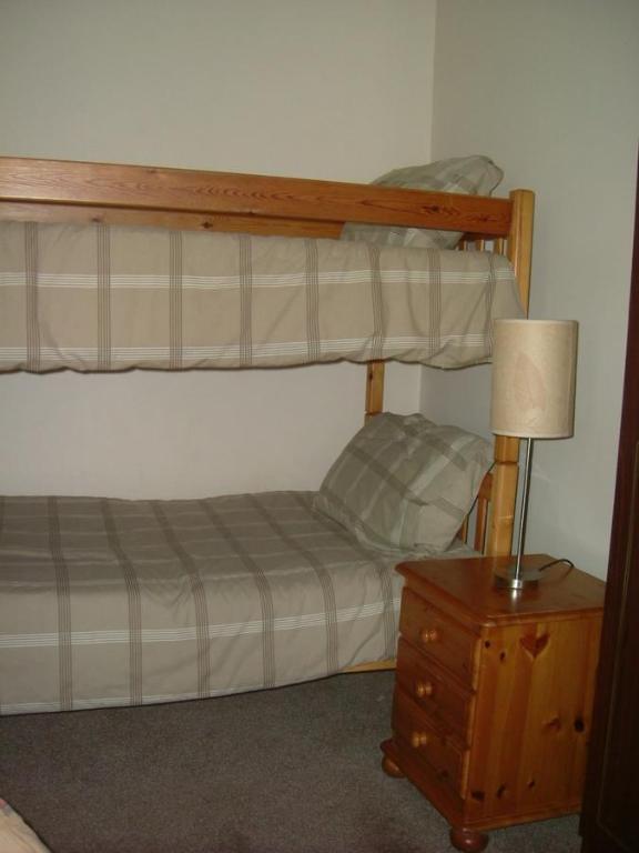 St Clements萨拉塔客舍的一间卧室设有两张双层床和一张带台灯的桌子