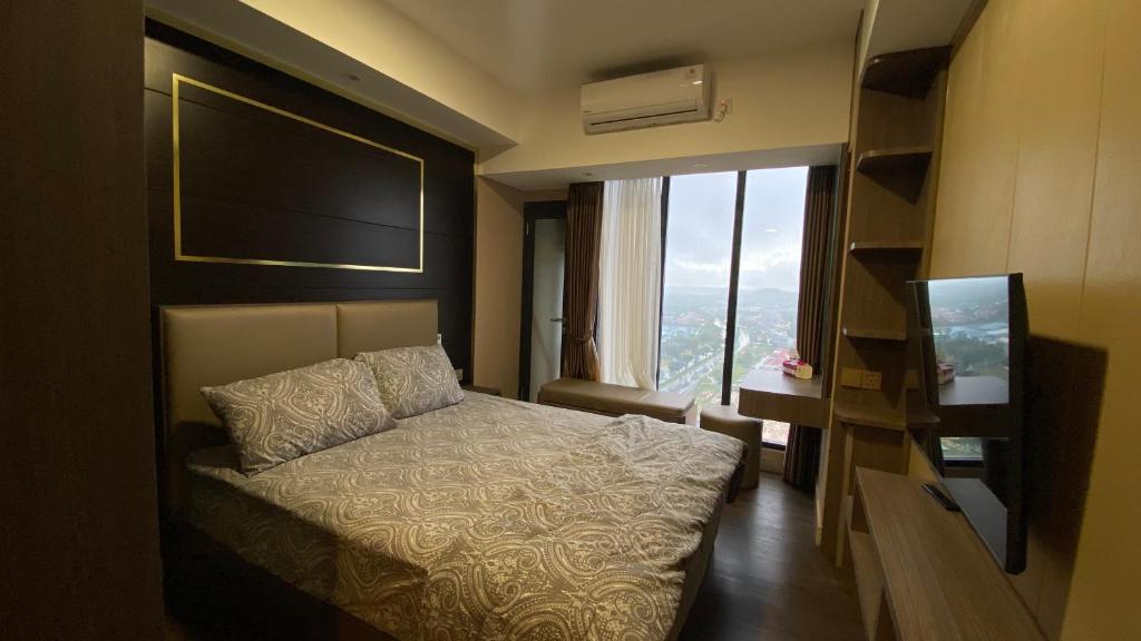 巴淡岛中心Meisterstadt Pollux Habibie Apartment by uhomeid的酒店客房设有一张床和一个大窗户