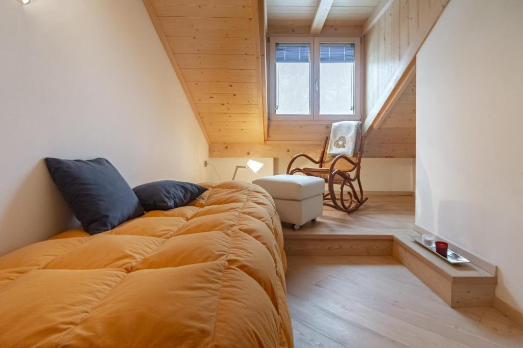 普雷达佐DolomiApartments - Appartamento Orso Bruno的一间带大床和楼梯的卧室