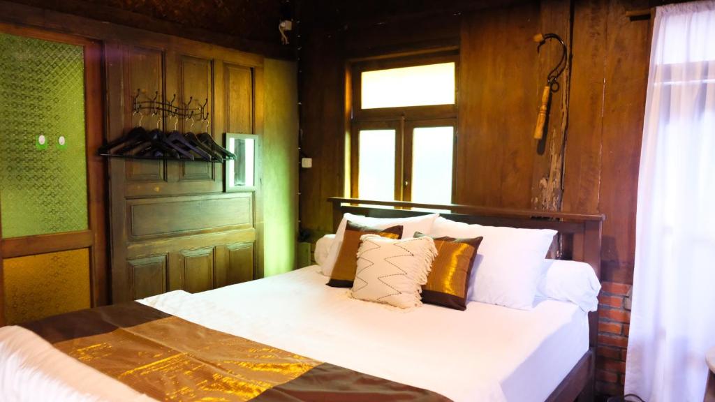 日惹Jogja ethnic house的一间卧室配有带白色床单和枕头的床。