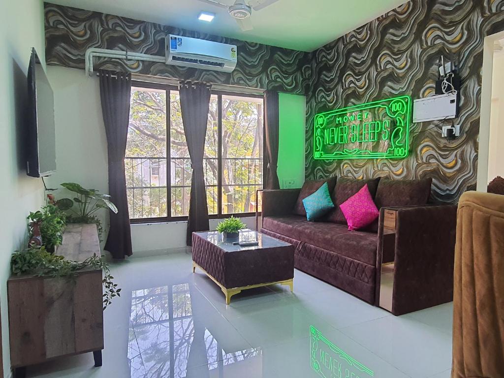 孟买OSI Apartments Khar West的客厅配有沙发和墙上的标志