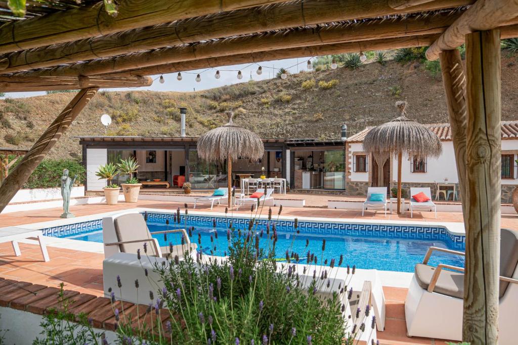 阿洛拉Finca Las Hierbas B&B的一个带椅子的游泳池,一个度假胜地