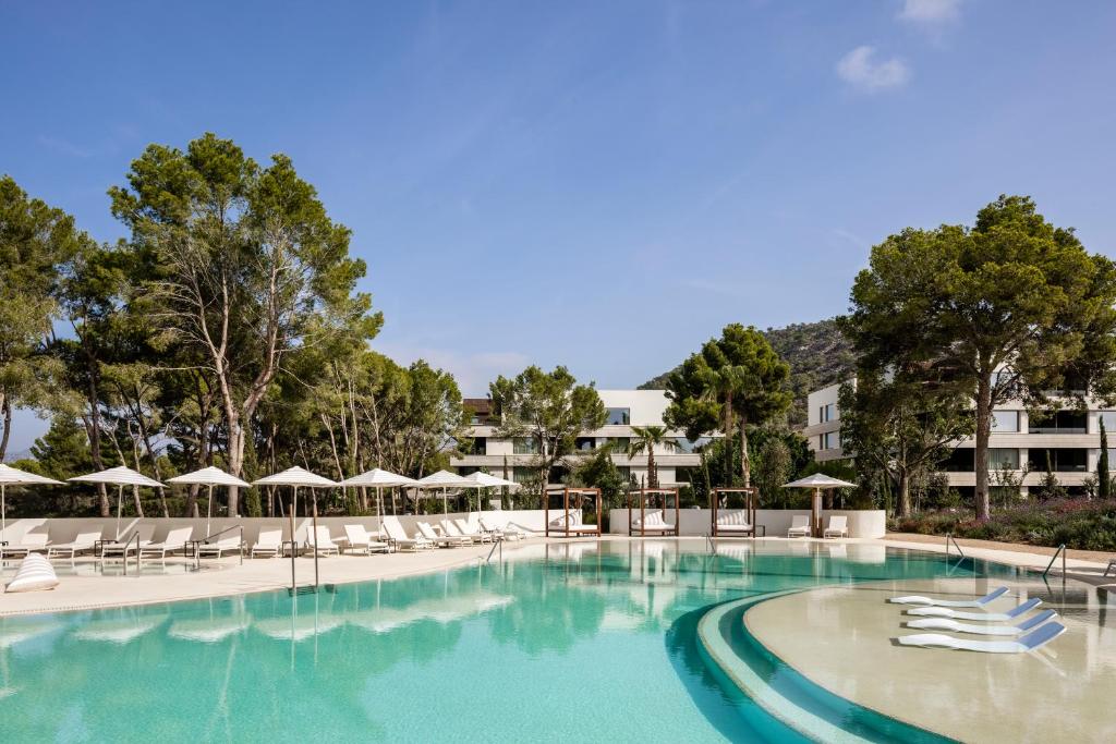 圣蓬萨Kimpton Aysla Mallorca, an IHG Hotel的一个带椅子和遮阳伞的大型游泳池