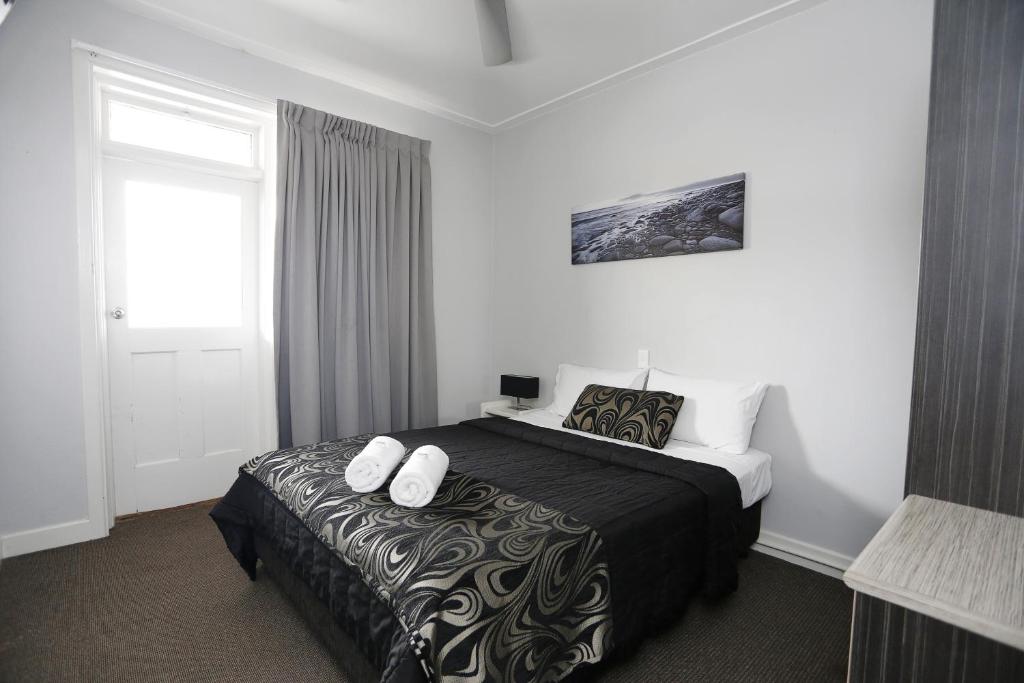 安特兰斯湖滨酒店的一间卧室配有一张带两条白色毛巾的床