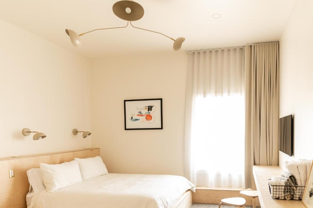 Havre-AubertPetit hôtel de la Montagne的一间卧室设有一张床和一个窗口