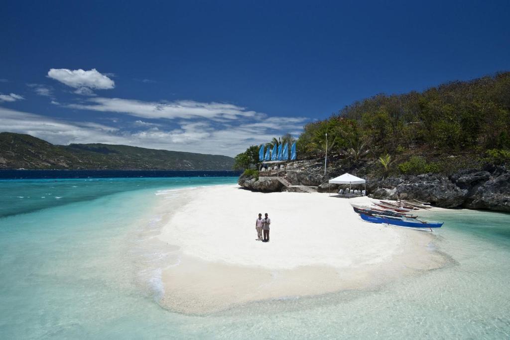 苏米龙岛Bluewater Sumilon Island Resort的两个人站在水边的海滩上