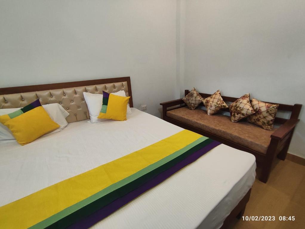 德拉敦Hotel StudioZ Sahastradhara的客房内的两张床和色彩缤纷的枕头