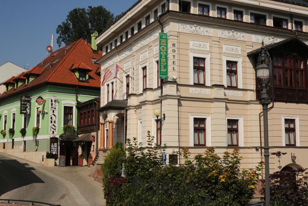 班斯卡-比斯特里察库利亚酒店的一座白色的大建筑,上面有绿色的标志