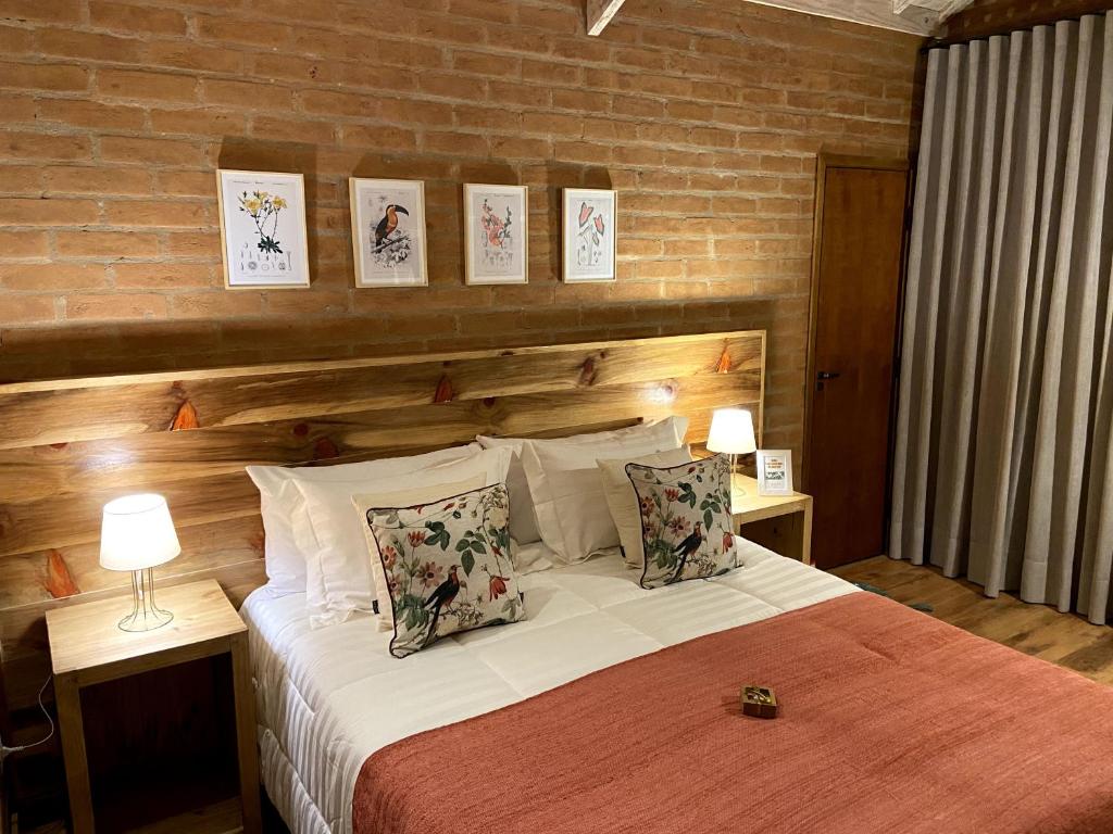 圣安东尼奥-杜皮尼亚尔Chalés Ceuci的一间卧室配有一张带两盏灯的床,墙上挂有图片