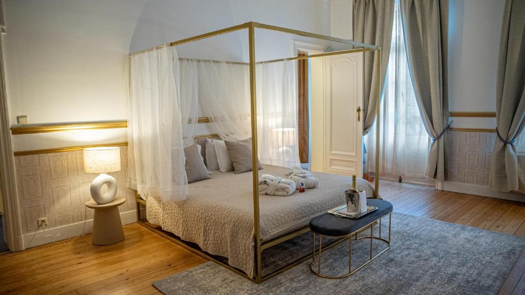 布鲁塞尔Hotel de Maître de Vaughan的一间卧室配有一张天蓬床和一张桌子