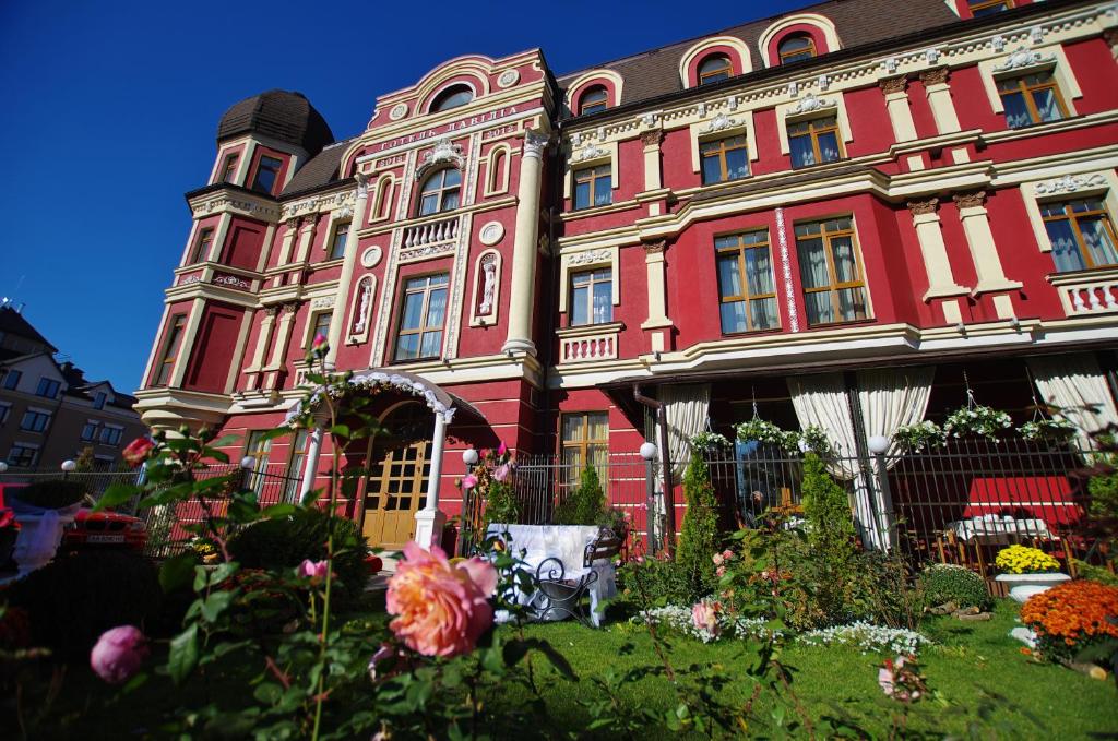 基辅拉威立雅酒店的一座红色的大建筑,前面有鲜花
