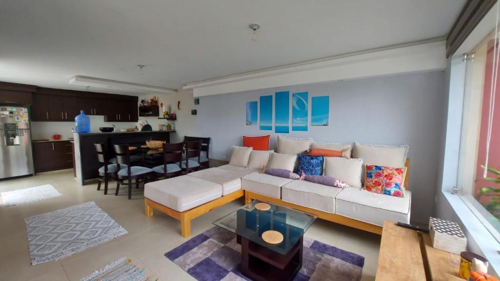 巴尼奥斯Tu confort en Los Andes的一间带白色沙发的客厅和一间厨房
