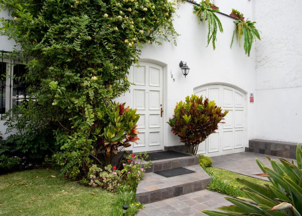 利马Lima 18 Boutique的白色的房子,有白色的门和植物