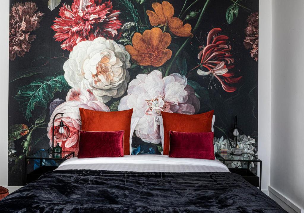 巴黎123paris city的一间卧室配有花卉壁纸和一张带红色枕头的床