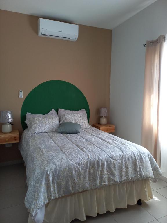 SiguatepequeHotel y Plaza JMI的一间卧室配有一张大床和绿色床头板