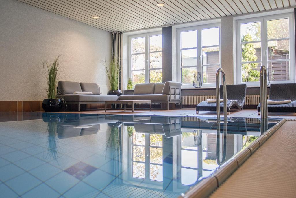 温特贝格Boutique-Hotel Weigels Bergfreiheit的一个带沙发和椅子的大型游泳池