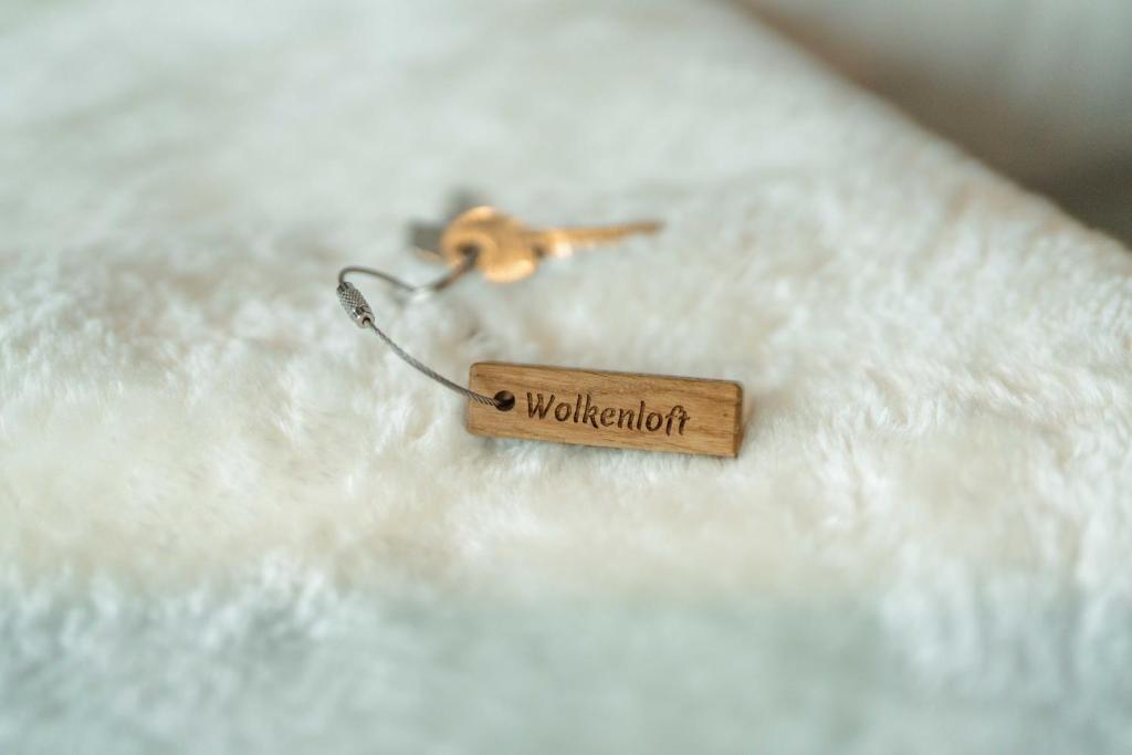 希尔克道夫Wolkenloft mit Meerblick und Schwimmbad - Haustiere willkommen的项链上带有巫术字的小木标签