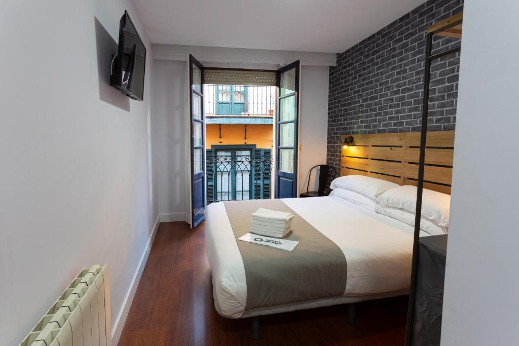 毕尔巴鄂Casual Mardones的一间卧室设有一张床和砖墙