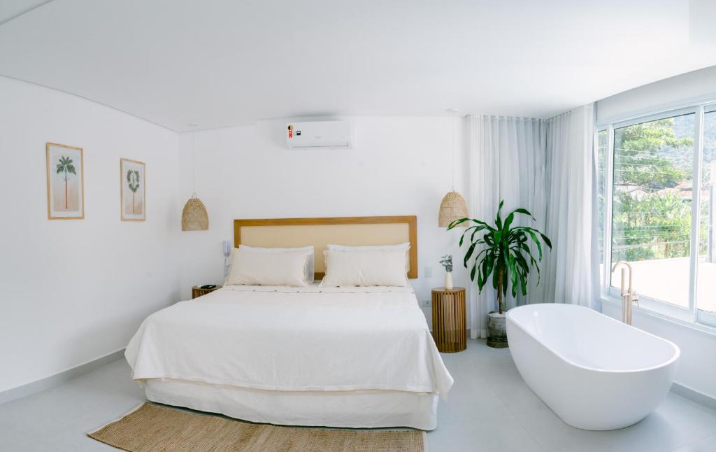 马利西亚斯Olisa Hotel Boutique的白色卧室设有一张大床和浴缸