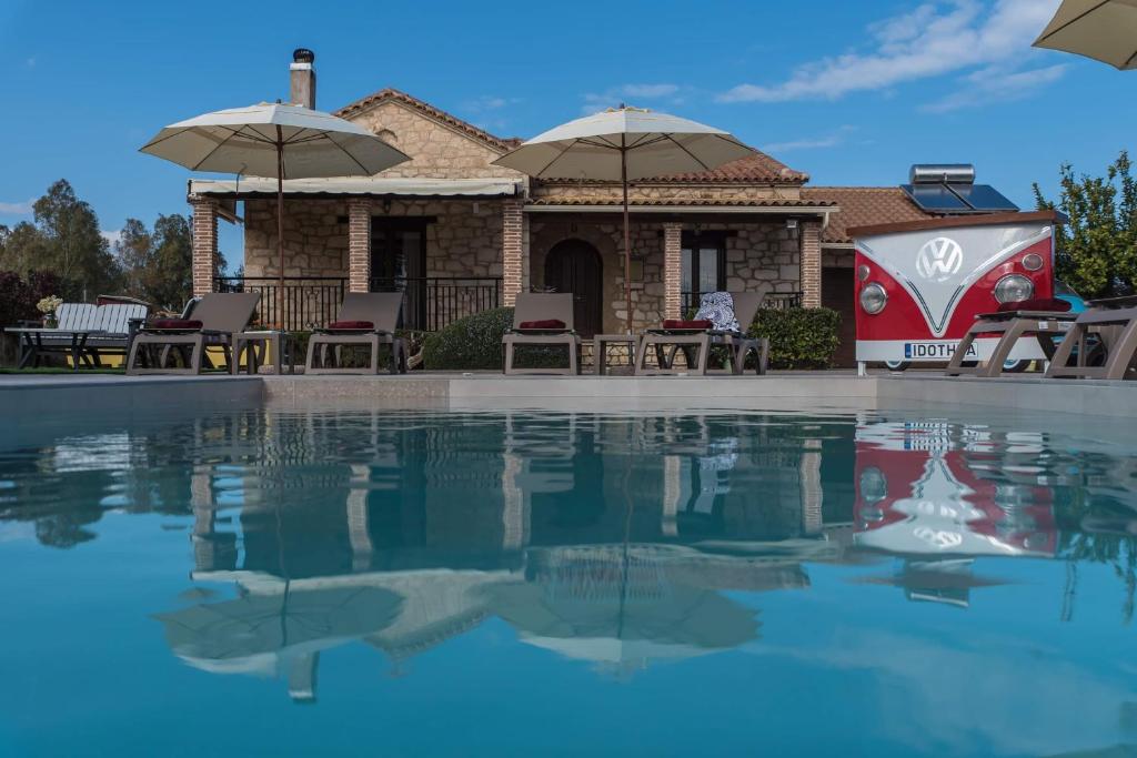 KalpakiIdothea Stone Villa的一座带游泳池和遮阳伞的房子