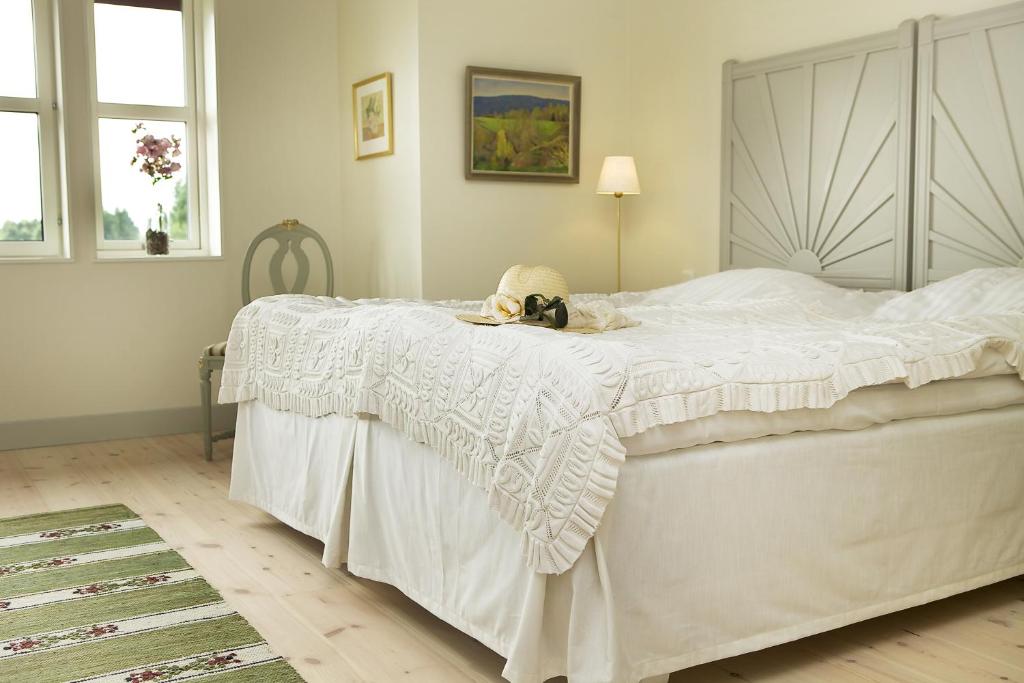 图什比萨尔斯特姆斯加登酒店的卧室配有一张白色的床,上面有一只动物填充物